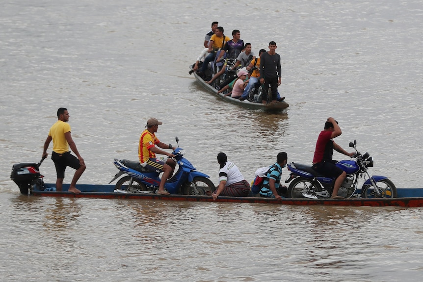 People cross a river in two boats.