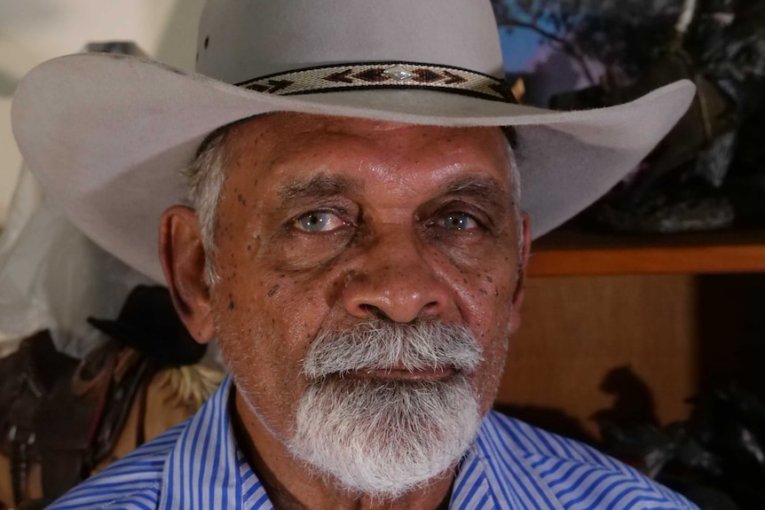 An older Indigenous man with a white beard, wearing a hat.