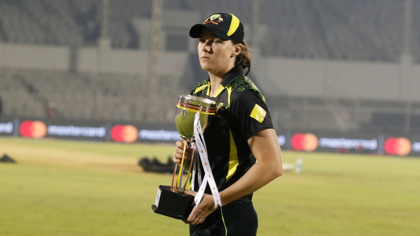 Australia's Tahlia McGrath holds a trophy after beating India in a Twenty20 series.