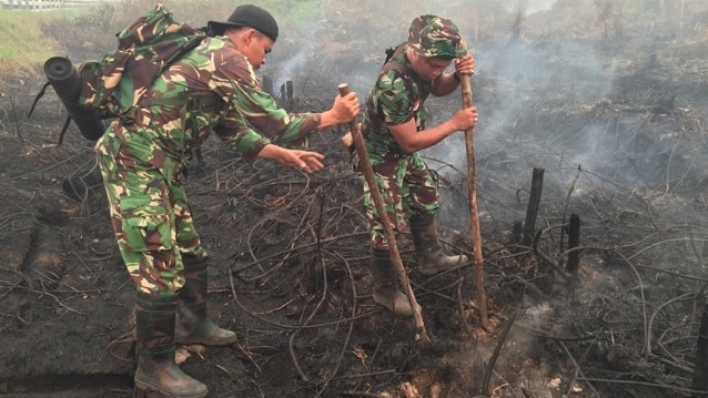 Soldiers trying to extinguish smoke.