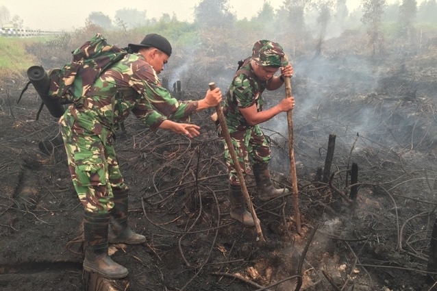 Soldiers trying to extinguish smoke.