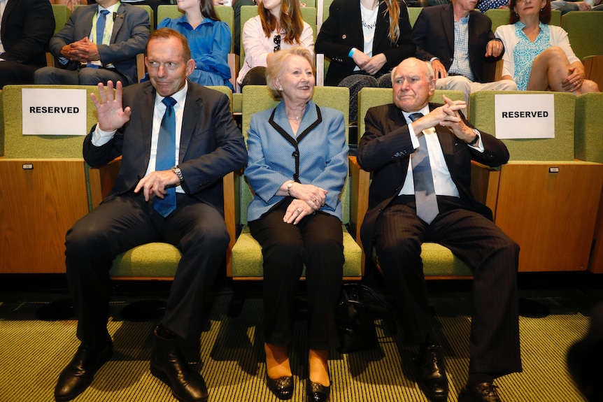 Tony Abbott, Jeanette Howard and John Howard sit in the crowd at the Liberal election launch. 