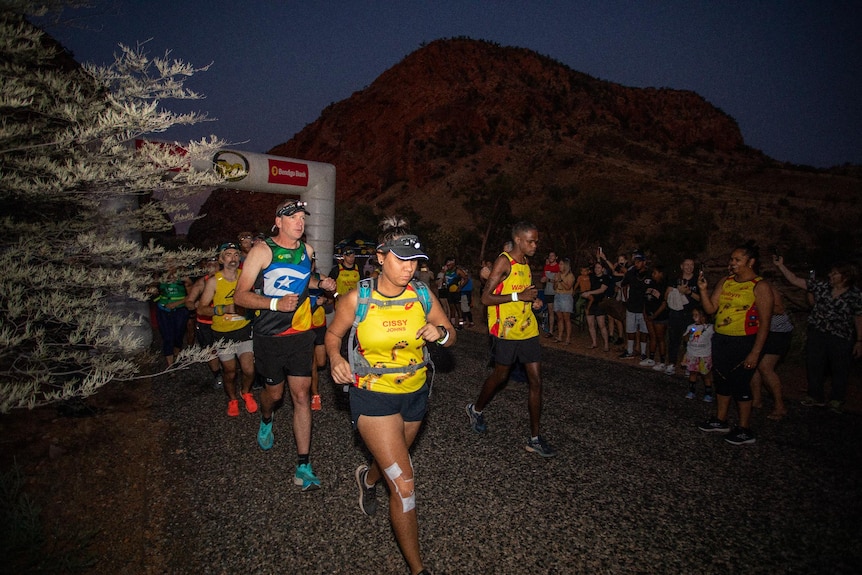 Cecilia Johns runs ahead of two other participants during the night leg of a marathon in the Northern Territory.