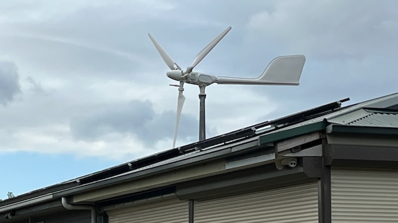 The wind turbine seen over a neighbour's fence