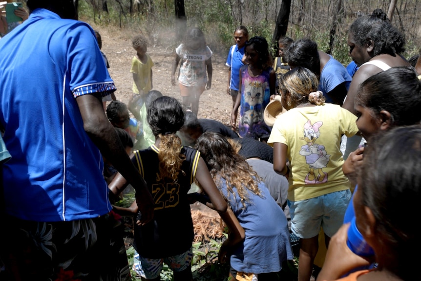 Students gather around a smoking ceremony. 