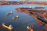 An aerial shot over a port with ships moving in and out 