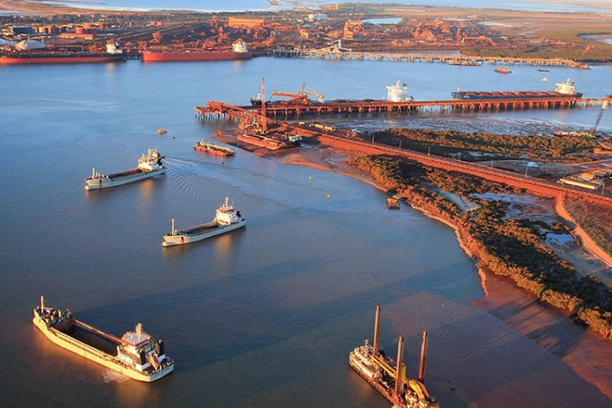 An aerial shot over a port with ships moving in and out 