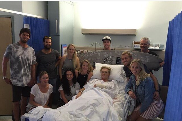 Brett Connellan in hospital surrounded by friends.