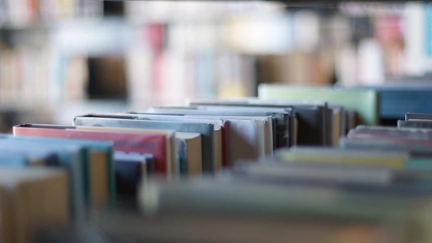 A close up of books on a shelf in a library.