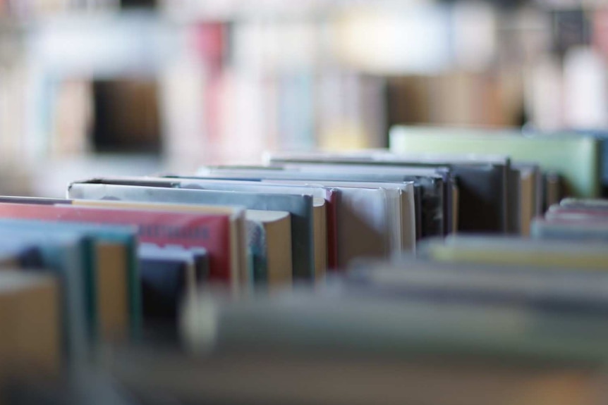 A close up of books on a shelf in a library.