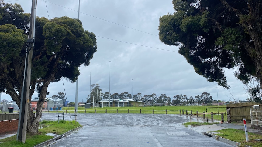 A public oval at the end of road beneath a rainy sky.