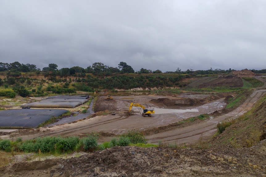 an open pit area with a bulldozer in the middle