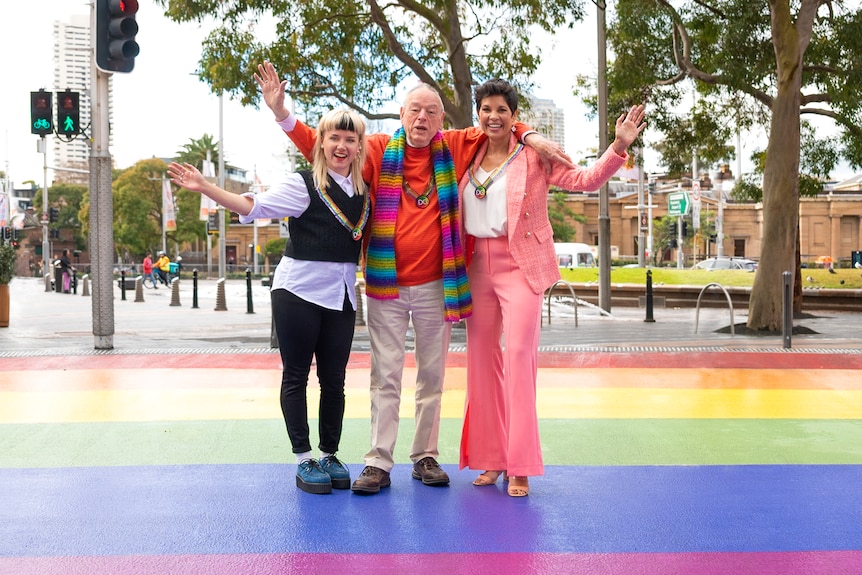 Rudy Jean Rigg, Peter de Waal and Narelda Jacobs pose on a rainbow crossing in Sydney.