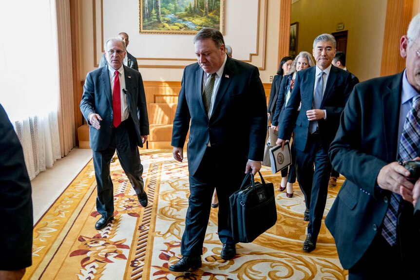 Mike Pompeo and Sung Kim walk through a hallway at the Park Hwa Guest House in Pyongyang.
