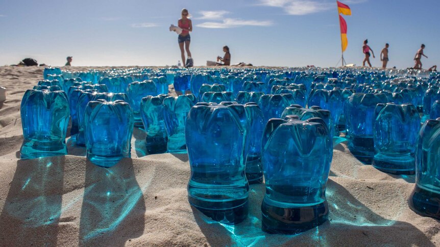 Blue plastic bottles in the sand