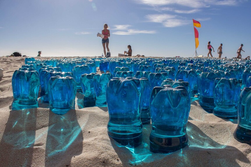 Blue plastic bottles in the sand