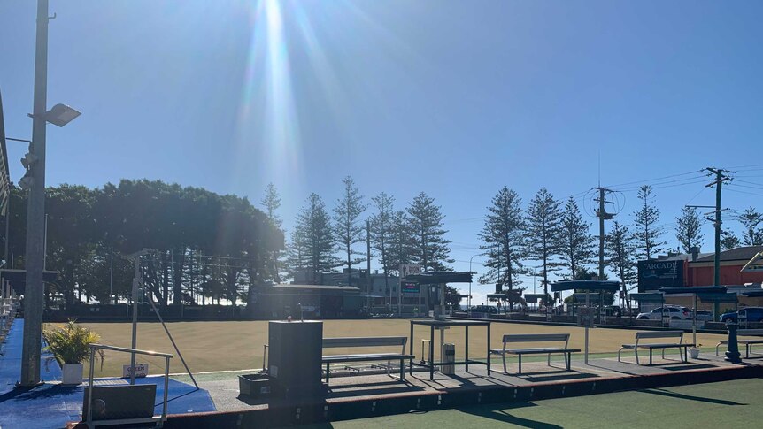 Empty Burleigh Heads Bowls Club green with sun streaming down