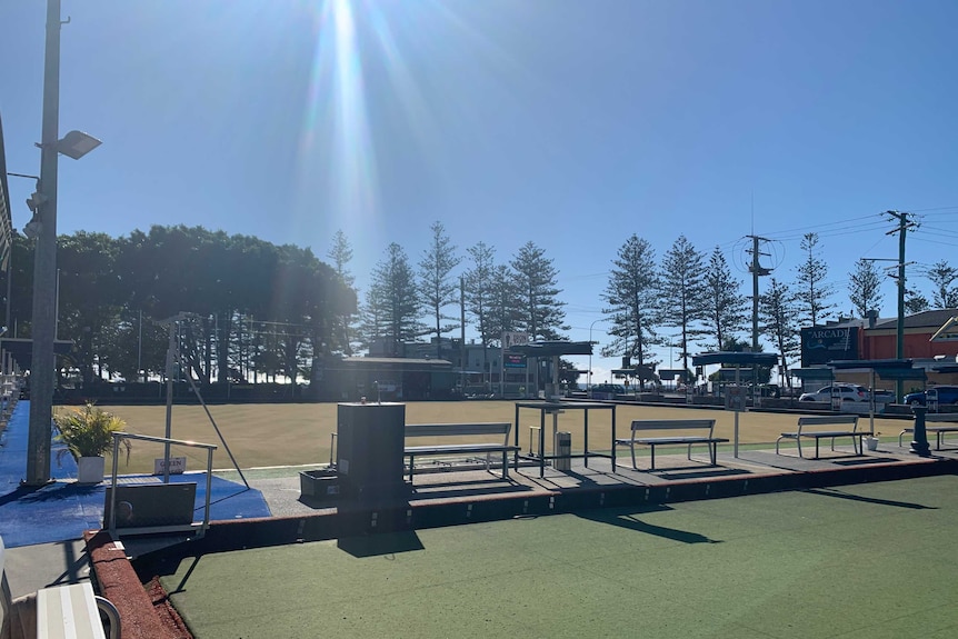 Empty Burleigh Heads Bowls Club green with sun streaming down