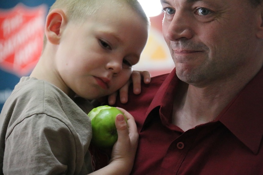 Ace and father David Bromley enjoying an apple at the Salvation Army.