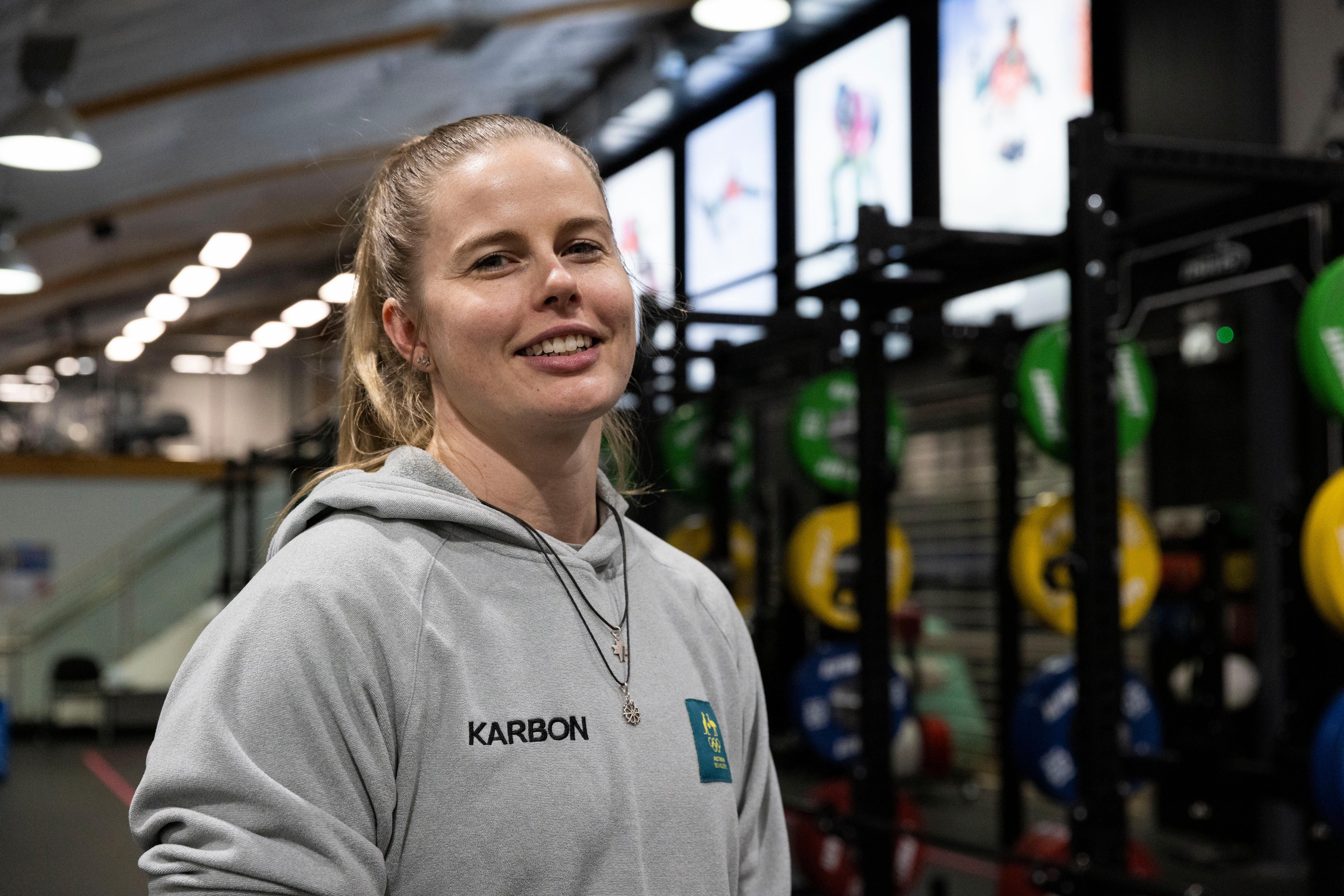 Una mujer está parada en un gimnasio. 