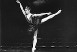 A female ballet dancer poses on stage