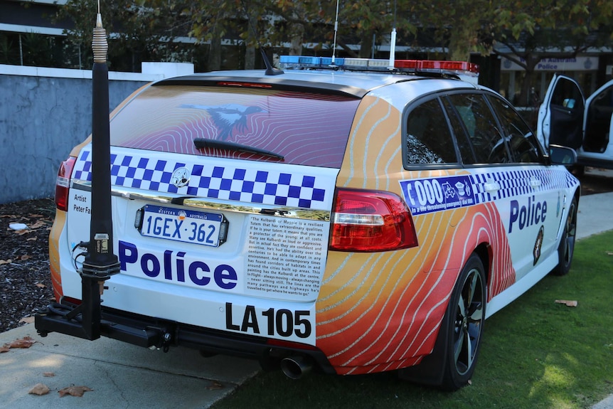 A police car viewed from behind featuring a bright indigenous art design.
