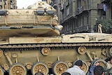 Protesters pray in front of army tanks at Tahrir Square.