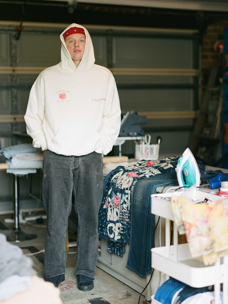 Riley 'Rejjie' Fanning stands in his garage with his clothes.