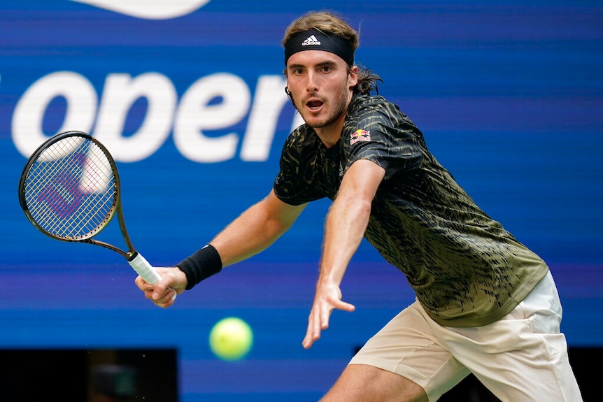 Stefanos Tsitsipas hits a ball.