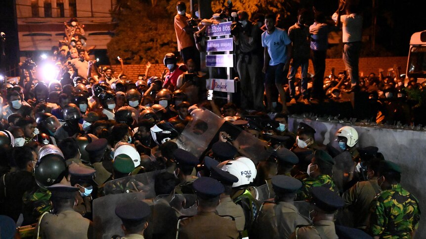 People clash with riot police in the night as they demonstrate outside Sri Lanka President's home.