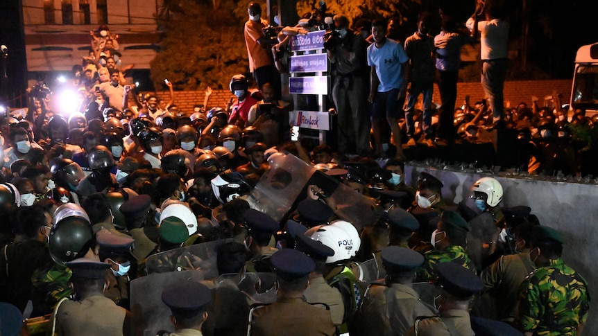 People clash with riot police in the night as they demonstrate outside Sri Lanka President's home.