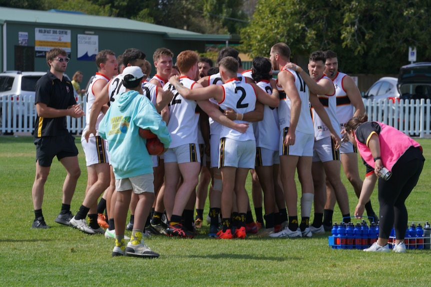 A group of footballers in a huddle.