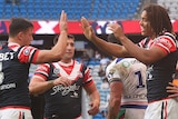 Sydney Roosters players congratulate Dominic Young on a try against the Warriors in an NRL game.
