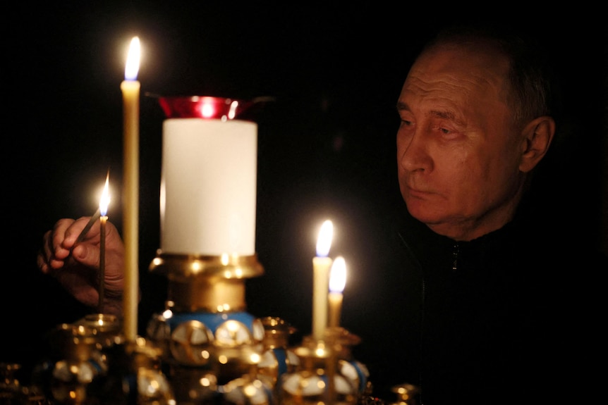 俄罗斯总统普京点燃蜡烛悼念恐袭事件中的遇难者。