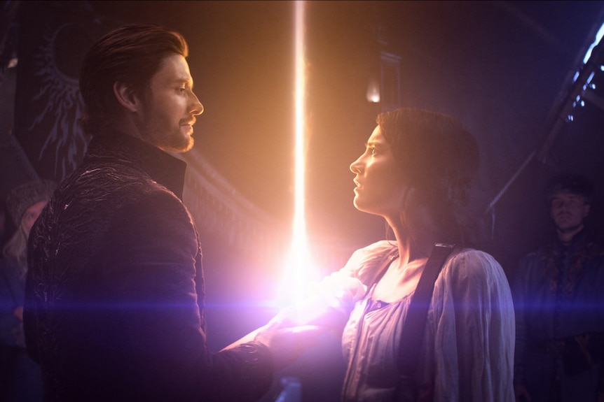 A light erupts between a man and a woman.