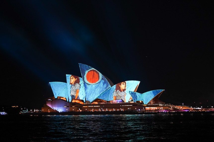 opera house sails lit up with a young woman on the opening night of the vivid festival 2024
