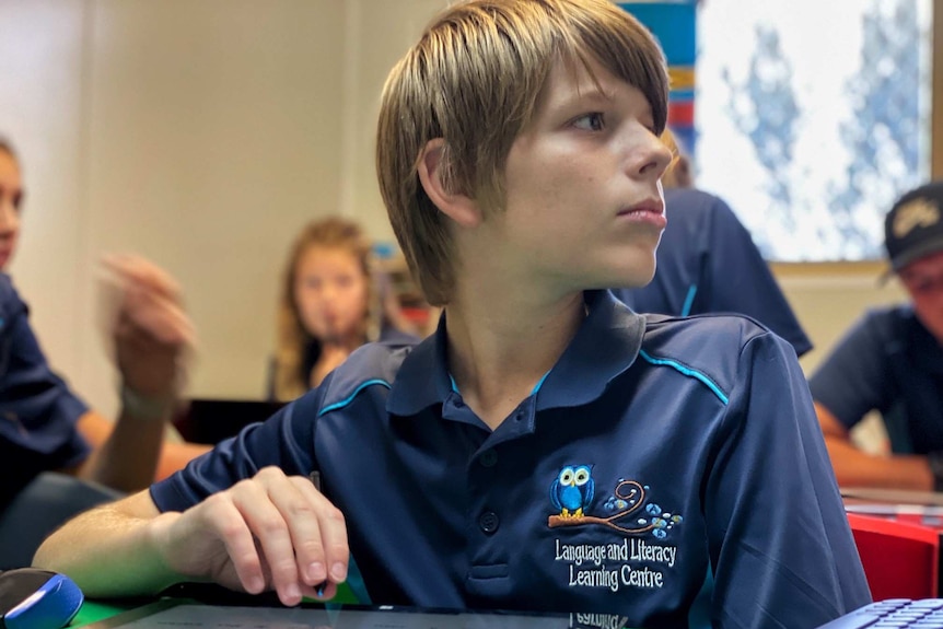 Boy at school desk with ipad