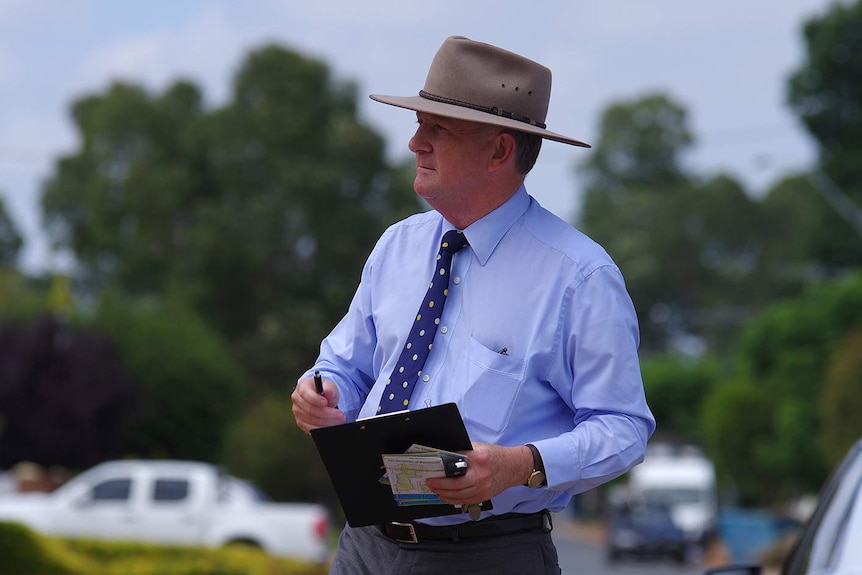 John Day pictured outside, holding a clipboard.