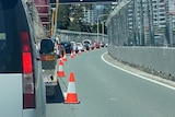 Vehicles queued up along a road that is being converted into race-track street circuit. 