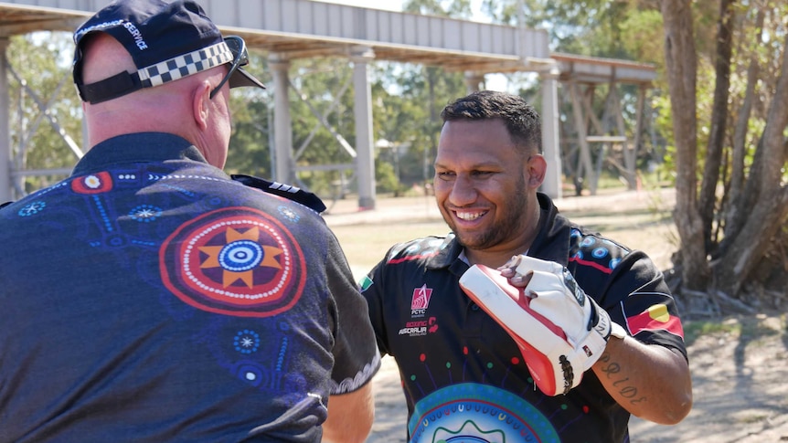 Aboriginal boxing coach Malachi Johnson practices his technique with Bundaberg Senior Constable Mick Gray at a park in Bundaberg