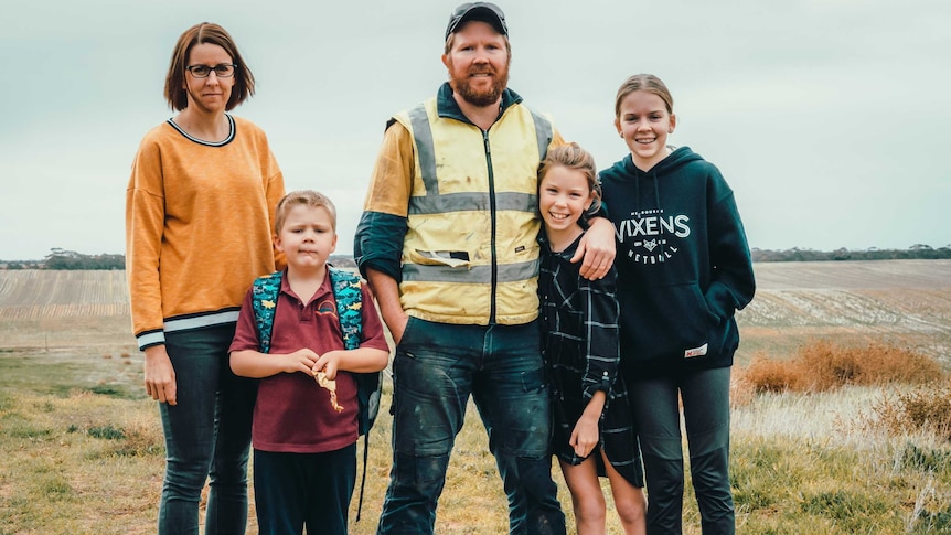 Lara and Jim Wakefield stand with their three children in a field on their family farm at Walpeup, in Victoria's north-west.