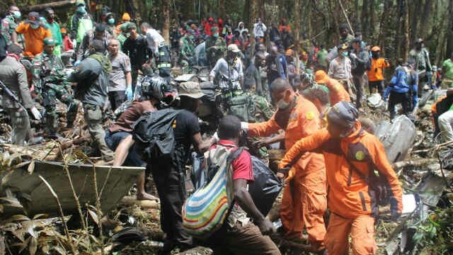 Indonesian search and rescue team members recover bodies from the wreckage of the Trigana Air flight that crashed in Papua