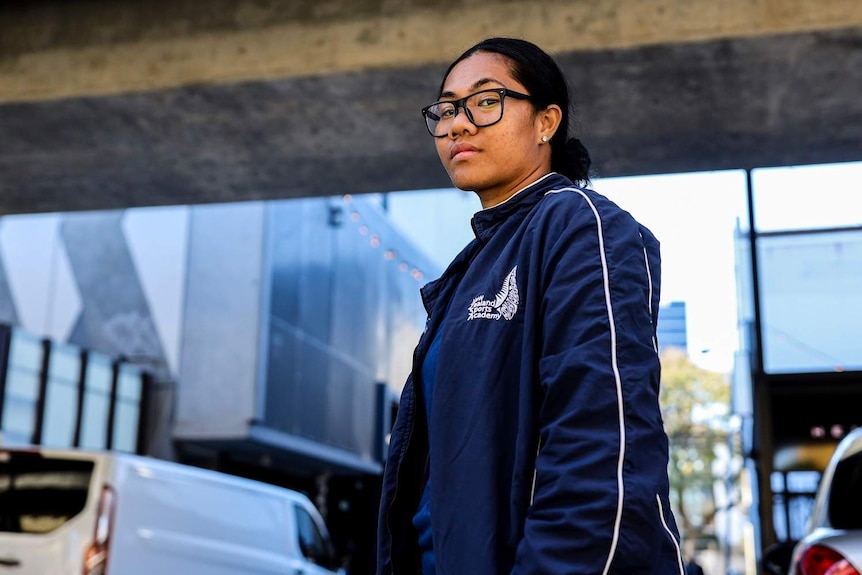 Sulu Feagiai, a young worker, stands in an alleyway in Brisbane