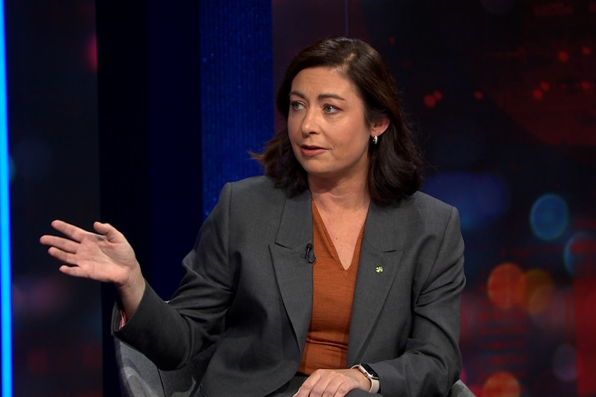 Une femme sur un panel répond à une question en position assise. 