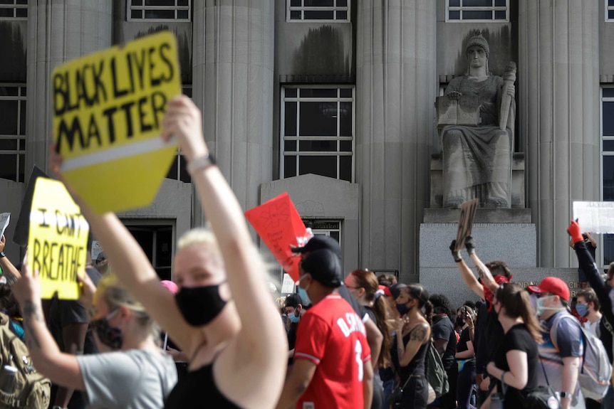 Protesters walk past the Mel Carnahan Courthouse in St Louis, Missouri during anti-police brutality protests.