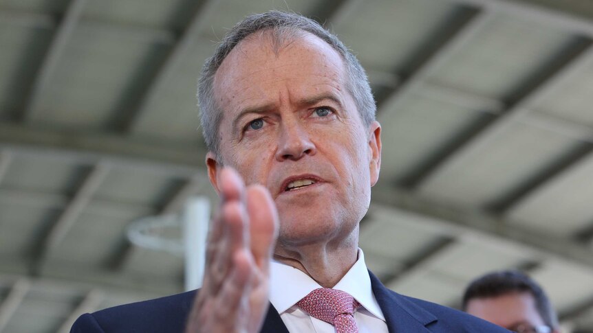 Bill Shorten gestures with a hand and looks into the distance mid-speech.