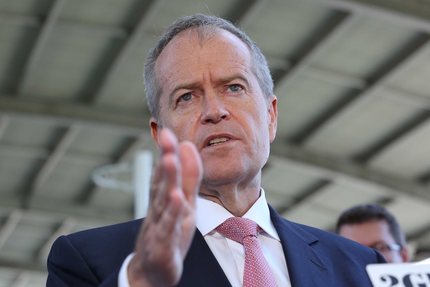 Bill Shorten gestures with a hand and looks into the distance mid-speech.