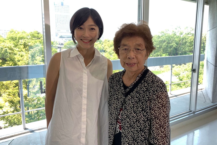 A younger woman stands next to an older woman.