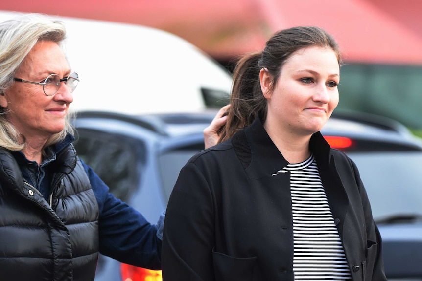 Jill Hickson Wran reaches out to her daughter Harriet Wran as they walk through a carpark.