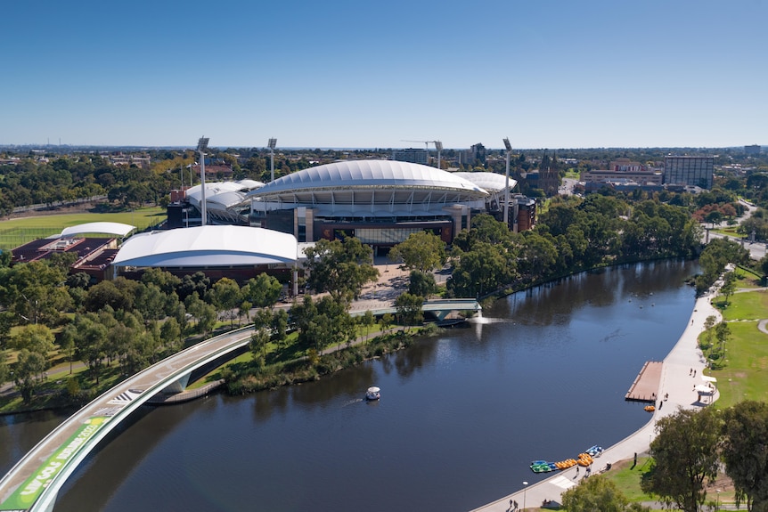 Adelaide Oval with the River Torrens and the pedestrian bridge with green signage on it